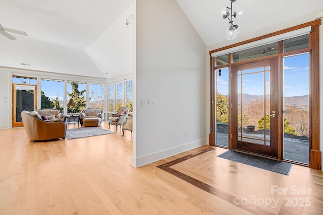 entrance foyer featuring a mountain view, light hardwood / wood-style flooring, high vaulted ceiling, and ceiling fan