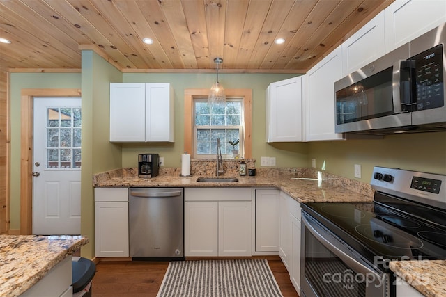 kitchen featuring white cabinetry, appliances with stainless steel finishes, sink, and decorative light fixtures