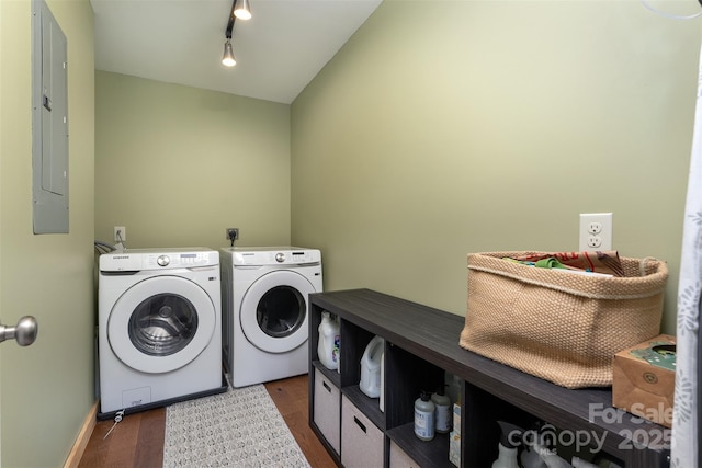 laundry room featuring dark wood-type flooring, electric panel, independent washer and dryer, and track lighting