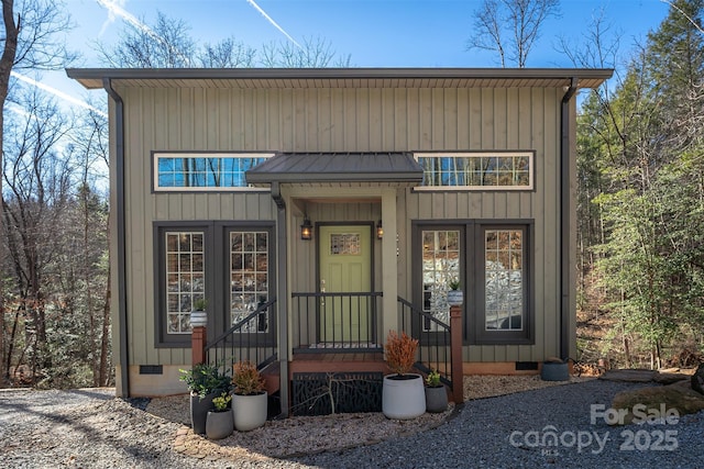 view of front of home featuring a standing seam roof, metal roof, crawl space, and board and batten siding