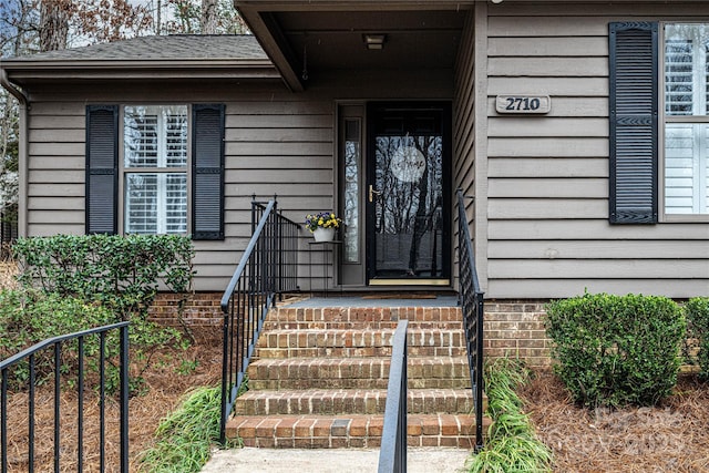 entrance to property with a shingled roof