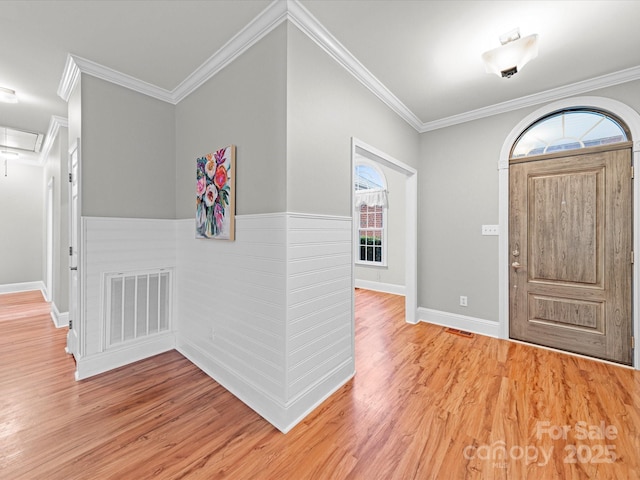 foyer entrance with hardwood / wood-style flooring and crown molding