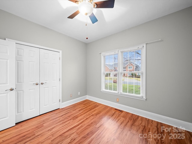 unfurnished bedroom with light hardwood / wood-style floors, a closet, and ceiling fan