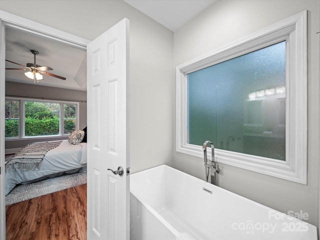 bathroom featuring hardwood / wood-style flooring, a bathing tub, and ceiling fan