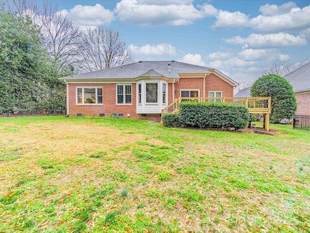 rear view of property with a yard and a deck