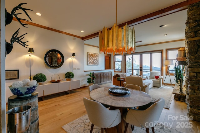 dining area featuring crown molding, a fireplace, and light wood-type flooring