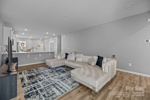 living room with sink and light wood-type flooring