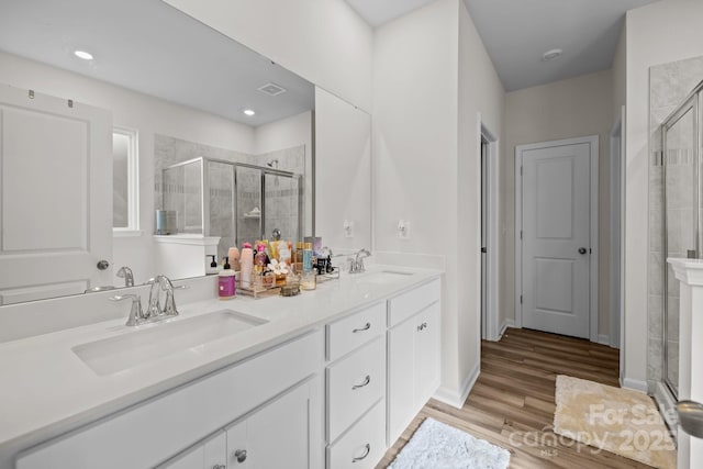 bathroom featuring vanity, wood-type flooring, and walk in shower