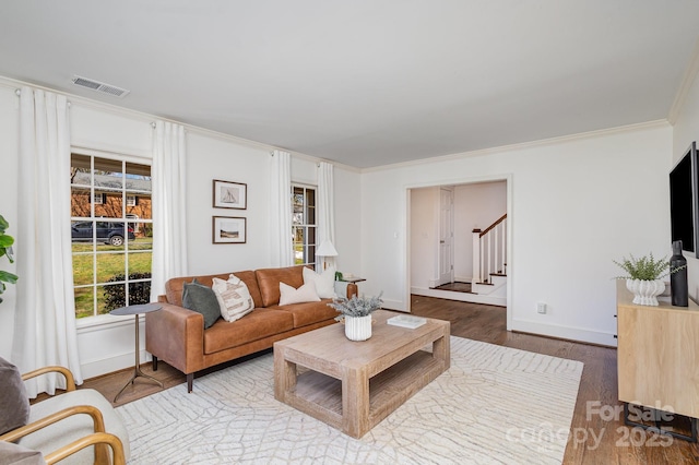 living room with baseboards, visible vents, stairway, ornamental molding, and wood finished floors