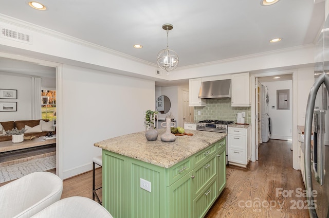 kitchen featuring white cabinets, a kitchen island, extractor fan, and decorative light fixtures