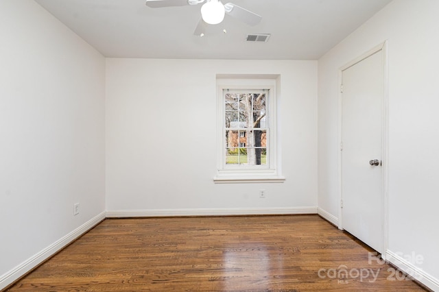 spare room featuring visible vents, ceiling fan, baseboards, and wood finished floors