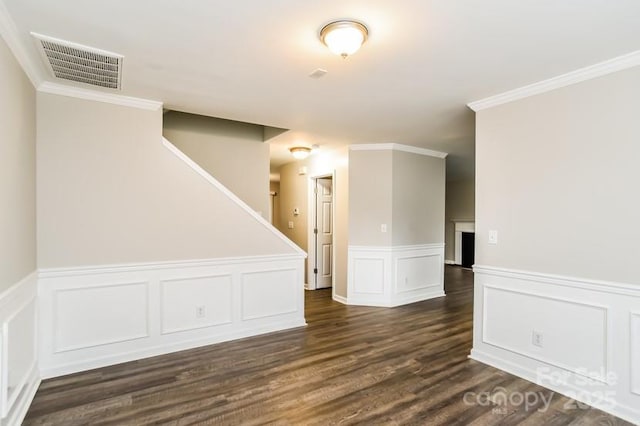 empty room with ornamental molding and dark wood-type flooring