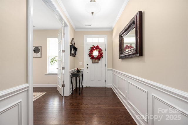 entryway with crown molding, plenty of natural light, and dark wood-type flooring