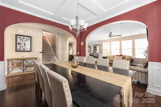 dining room with dark hardwood / wood-style flooring, ceiling fan with notable chandelier, coffered ceiling, and crown molding