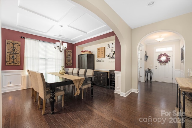 dining room with coffered ceiling, dark hardwood / wood-style flooring, and a chandelier