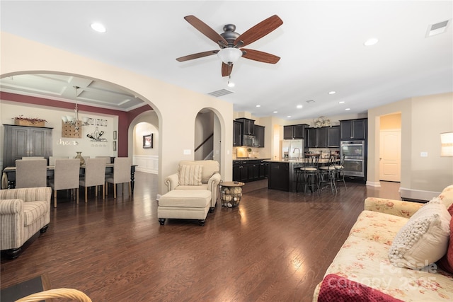 living room featuring coffered ceiling, dark hardwood / wood-style floors, and ceiling fan with notable chandelier