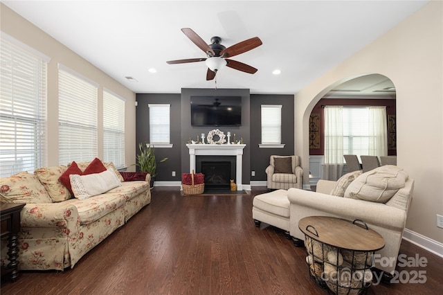 living room featuring dark wood-type flooring and ceiling fan