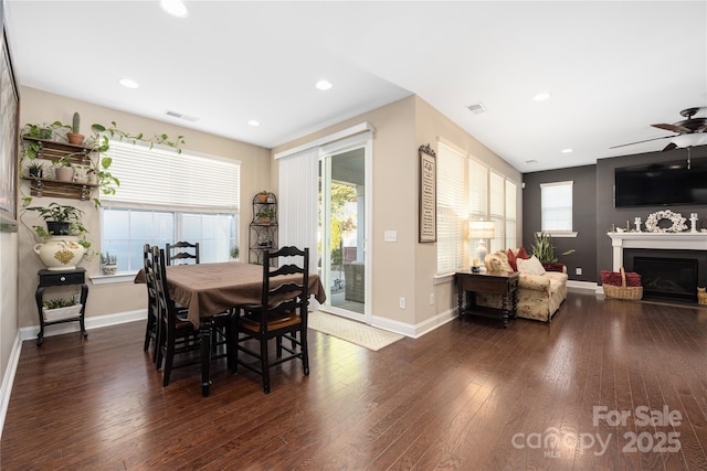 dining room with dark wood-type flooring, ceiling fan, and a healthy amount of sunlight