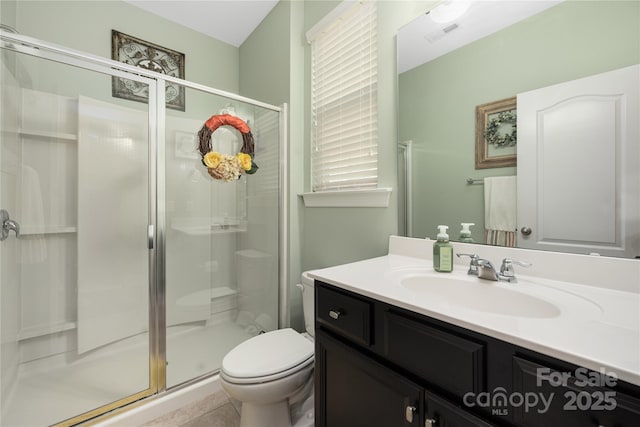 bathroom with vanity, toilet, and a shower with door