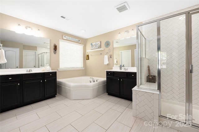 bathroom with vanity and shower with separate bathtub