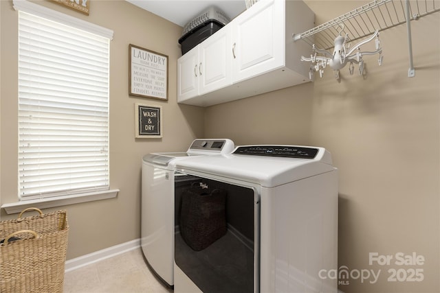 washroom featuring cabinets, light tile patterned flooring, and washer and clothes dryer