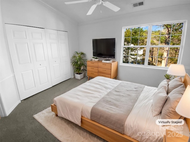 bedroom with dark colored carpet, ornamental molding, ceiling fan, and a closet