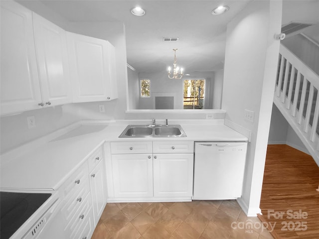 kitchen with decorative light fixtures, sink, white cabinets, a chandelier, and white appliances