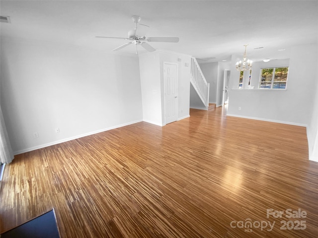 unfurnished living room featuring wood-type flooring and ceiling fan with notable chandelier