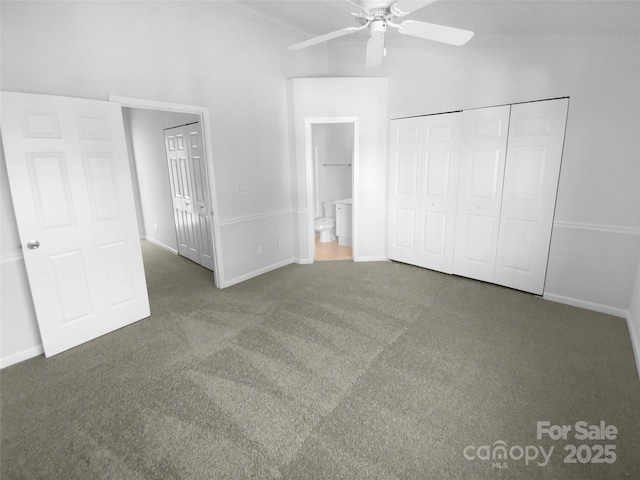 unfurnished bedroom featuring ceiling fan, ensuite bathroom, dark carpet, and a closet