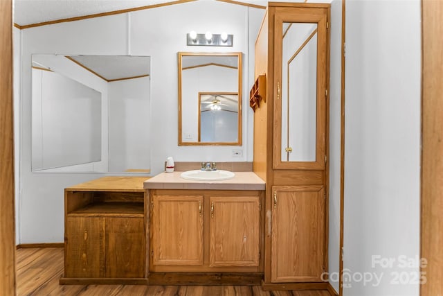 bathroom with vanity, hardwood / wood-style floors, and lofted ceiling