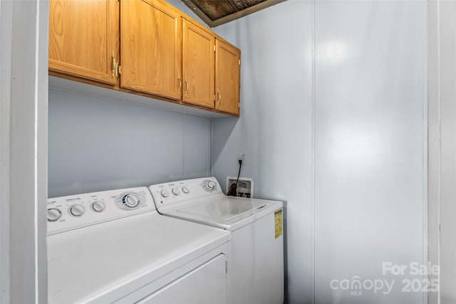 clothes washing area with cabinets and washing machine and dryer