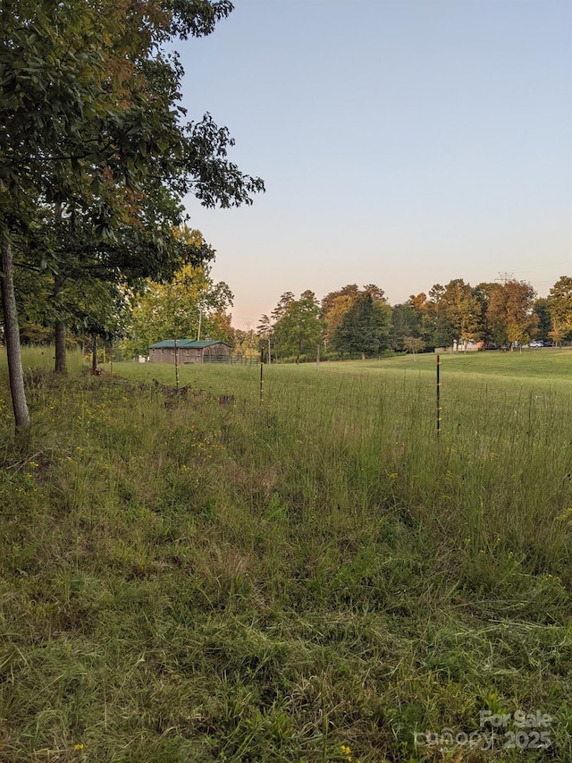 yard at dusk with a rural view