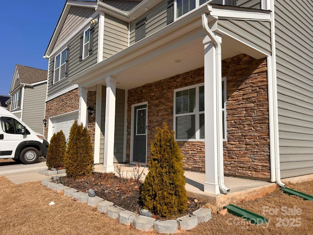 view of side of property with a garage and a porch