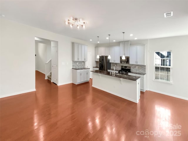 kitchen featuring pendant lighting, an island with sink, white cabinets, and appliances with stainless steel finishes