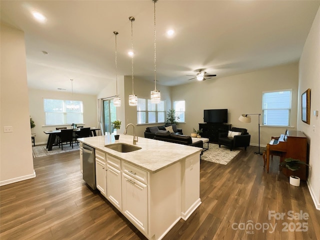 kitchen with sink, dishwasher, an island with sink, pendant lighting, and white cabinets