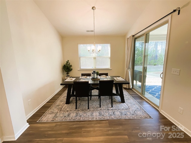 dining room with vaulted ceiling, dark hardwood / wood-style floors, and a notable chandelier