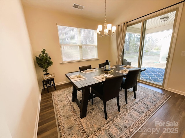 dining space featuring an inviting chandelier and dark hardwood / wood-style floors