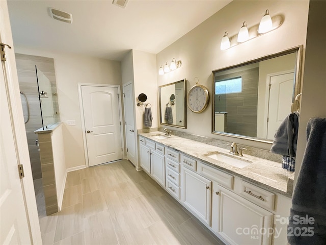 bathroom with tiled shower and vanity