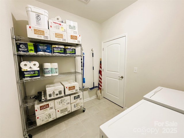 clothes washing area featuring washing machine and clothes dryer and light tile patterned floors