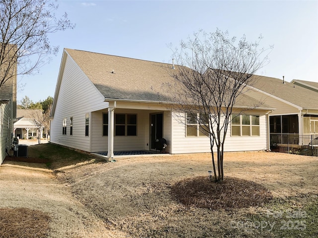 rear view of property with central AC