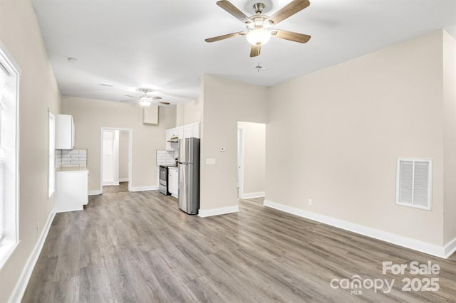 unfurnished living room with ceiling fan and light hardwood / wood-style floors