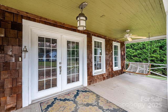 wooden terrace featuring french doors and ceiling fan