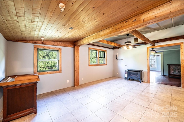 unfurnished living room featuring a healthy amount of sunlight, a wood stove, light tile patterned flooring, and wood ceiling