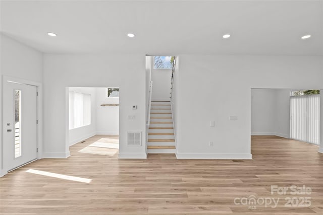 interior space with recessed lighting, visible vents, stairway, light wood-type flooring, and baseboards