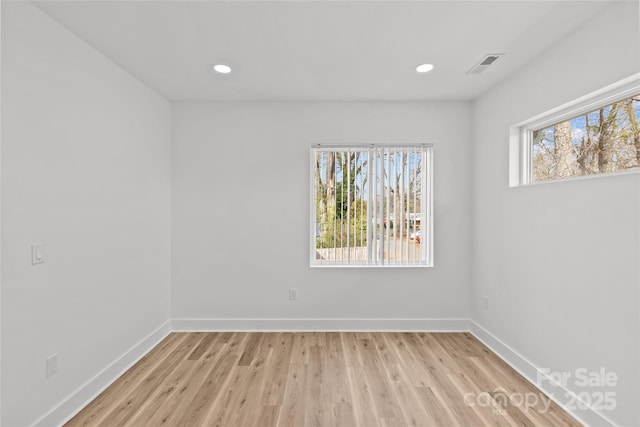 spare room with recessed lighting, visible vents, light wood-style flooring, and baseboards