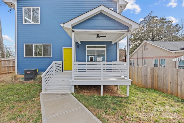 exterior space featuring ceiling fan, fence, a front lawn, and central AC