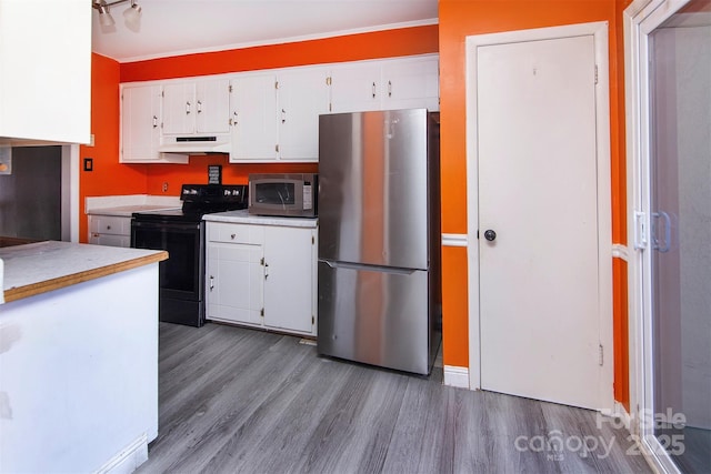 kitchen featuring hardwood / wood-style floors, stainless steel appliances, and white cabinets