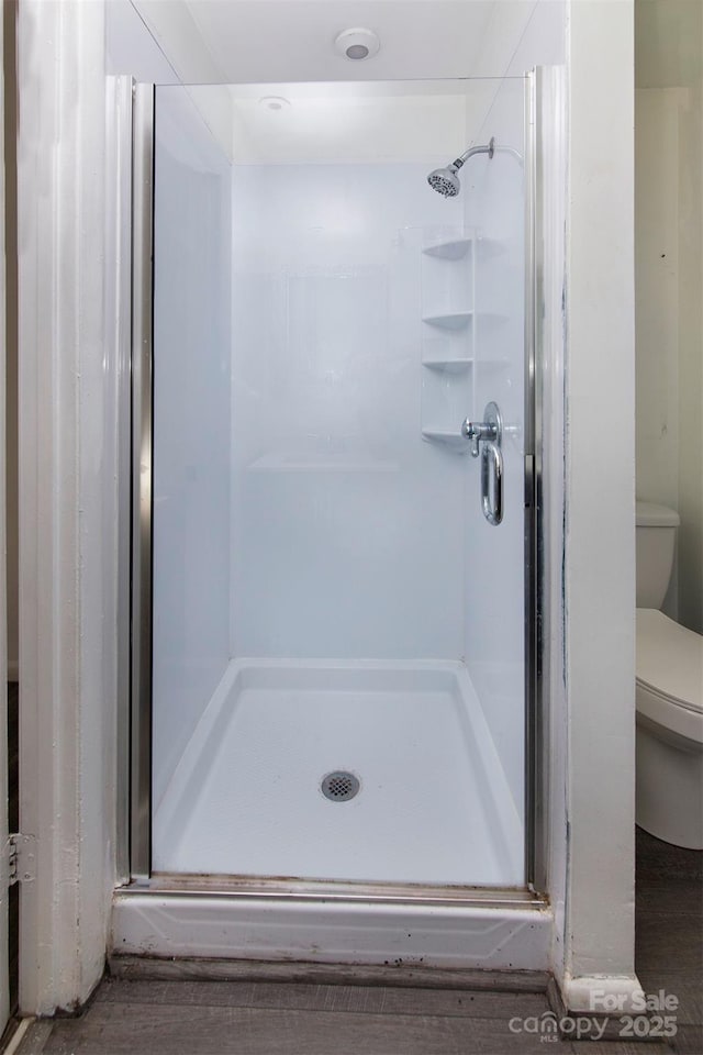 bathroom featuring an enclosed shower and toilet