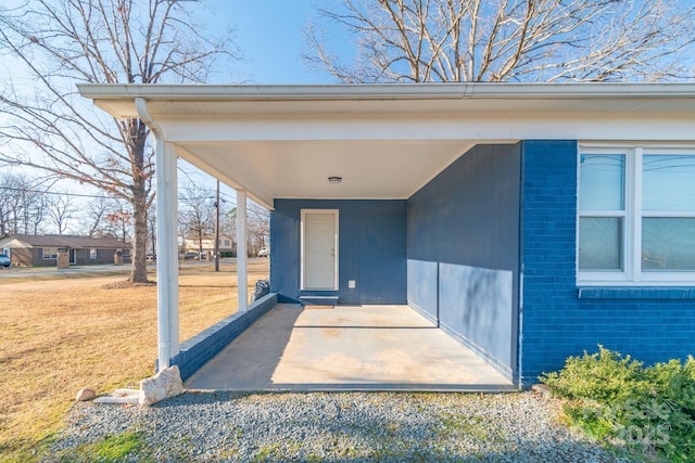 doorway to property featuring a yard and a patio