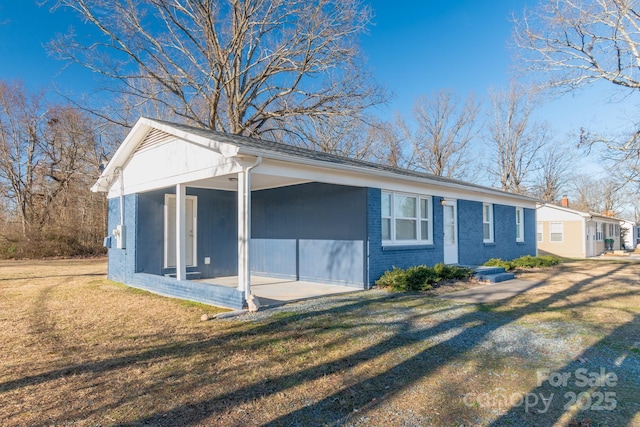 view of side of home featuring a yard and a sunroom